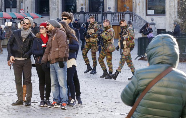 Du khách chụp ảnh trong khi các binh sĩ Bỉ tuần tra trước Cung điện Hoàng gia ở thủ đô Brussels. 