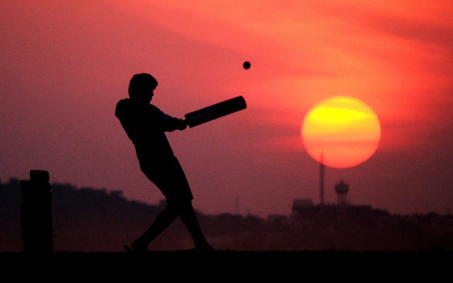 Cậu bé chơi cricket lúc mặt trời lặn ở Bhopal, Ấn Độ.