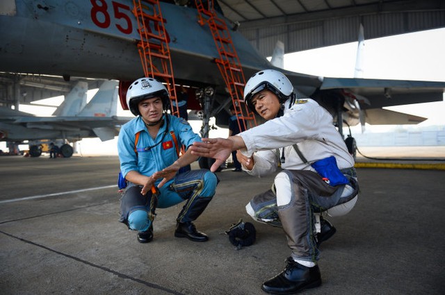 Đại tá Phan Xuân Tình, tham mưu trưởng trung đoàn 935, hướng dẫn lại một số thao tác quan trọng trong bài bay cho phi công 9X Bùi Văn Lập trước khi lên máy bay - Ảnh: Thuận Thắng