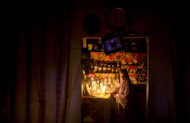 Một phụ nữ Palestine đốt nến để thắp sáng trong thời gian mất điện ở al-Shati tại thành phố Gaza.