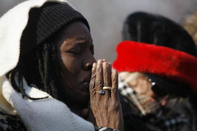 Một người phụ nữ da màu khóc và cầu nguyện khi theo dõi bài diễn văn nhậm chức của Tổng thống qua truyền hình.