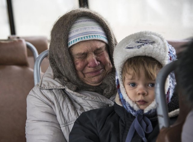 Người phụ nữ khóc khi ngồi cùng một bé trên xe bus trước khi sơ tán khỏi thị trấn Debaltseve, miền đông Ukraine.