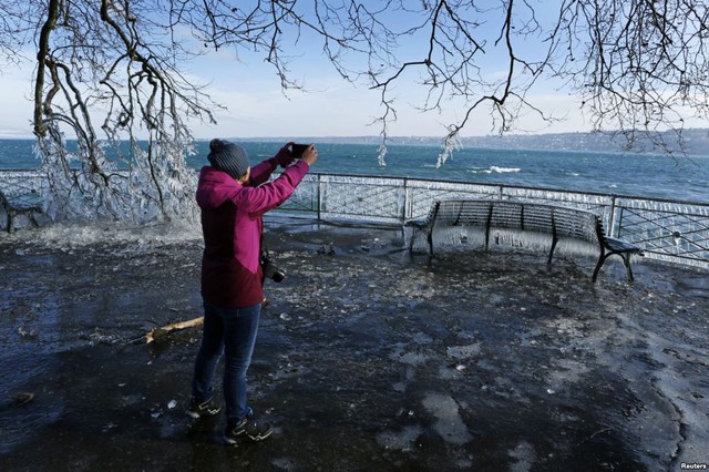Người phụ nữ chụp ảnh băng tuyết cạnh bờ hồ ở Geneva, Thụy Sĩ.