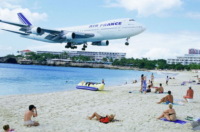 Một chiếc máy bay Boeing 747 của hãng hàng không Air France bay sát qua đầu các du khách trên bãi biển khi hạ cánh xuống sân bay quốc tế Juliana trên đảo Saint Martin, Caribbean.