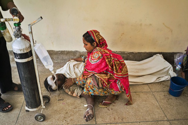 Người phụ nữ chăm sóc chồng đang được cấp cứu sau vụ sập một nhà máy xi măng ở thành phố cảng Mongla, Bangladesh, khiến 8 người thiệt mạng và hàng chục người khác bị thương.
