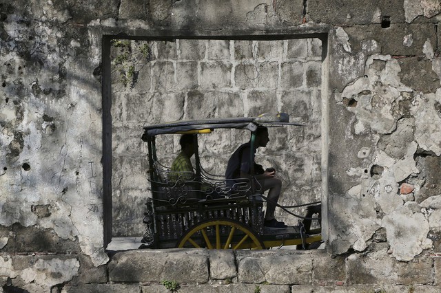 Du khách ngắm cảnh từ chiếc xe ngựa tại khu phố cổ Intramuros ở Manila, Philippines.