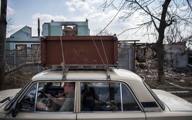 Người dân sơ tán cùng đồ dùng cá nhân sau khi các cuộc giao tranh tái diễn tại Jabunki, gần sân bay Donetsk, miền đông Ukraine.