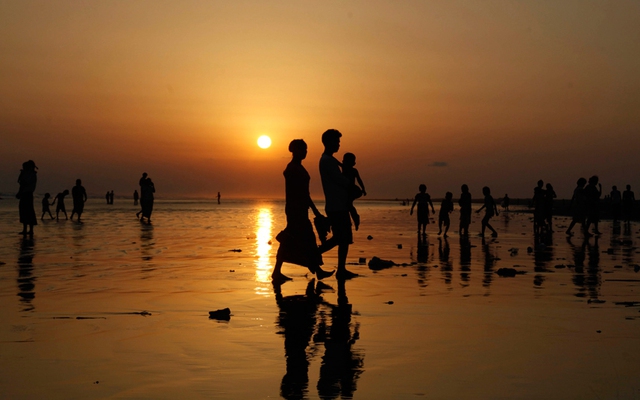 Mọi người dạo chơi trên bãi biển khi hoàng hôn xuống ở Sittwe, tây Myanmar.