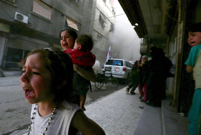 Trẻ em chạy trốn khỏi một vụ nã pháo nhằm vào thành phố Damascus, Syria.