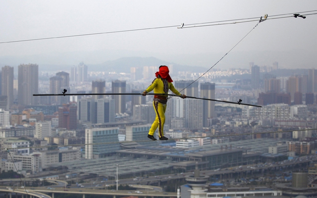 Một người đàn ông ở Tân Cương đã lập kỉ lục thế giới với tài bịt mắt và đi trên sợi dây nối giữa 2 tòa nhà chọc trời tại thành phố Côn Minh, tỉnh Vân Nam, Trung Quốc.