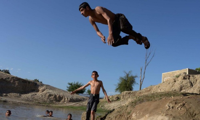 Trẻ em tắm mát dưới hồ nước trong một ngày nắng nóng ở Jalalabad, Afghanistan.