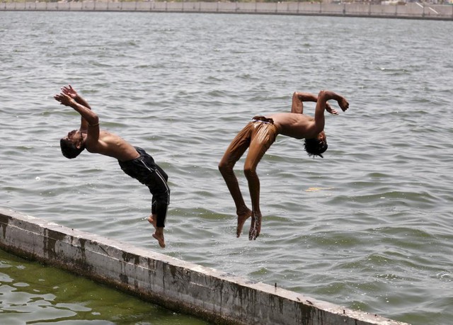 Các cậu bé nhảy xuống sông Sabarmati để tắm mát trong một ngày nắng nóng ở Ahmedabad, Ấn Độ.