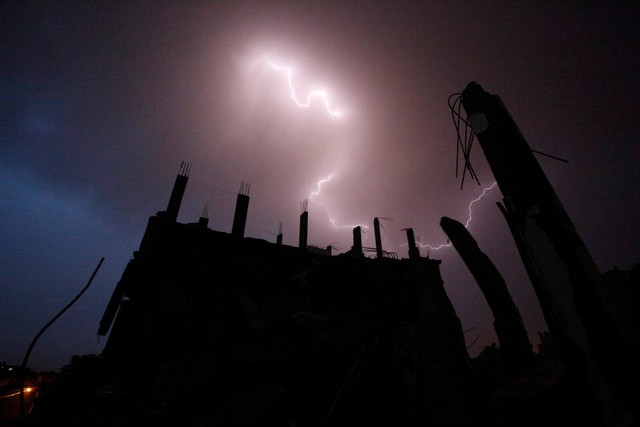 Sét đánh sáng lóa trên những tòa nhà đổ nát ở thành phố Gaza.