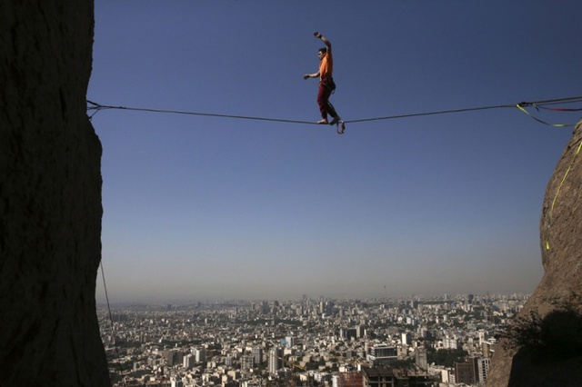 Hamed Heidari đi trên dây nối giữa hai vách núi nhìn xuống thành phố Tehran, Iran.