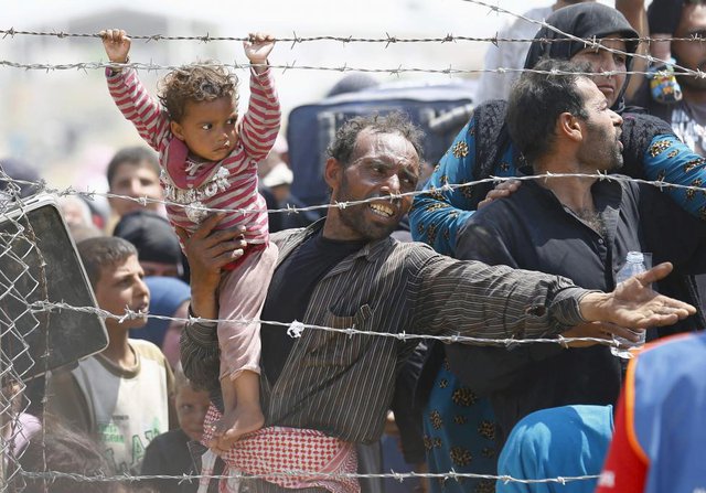Người tị nạn Syria tỏ rõ sự thất vọng khi đứng chờ sau hàng rào biên giới tại cửa khẩu Akcakale, tỉnh Sanliurfa, Thổ Nhĩ Kỳ.