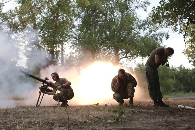 Binh sĩ Ukraine lấy tay bịt tai sau khi phóng rocket nhằm vào phe ly khai ở Donetsk, miền đông Ukraine.