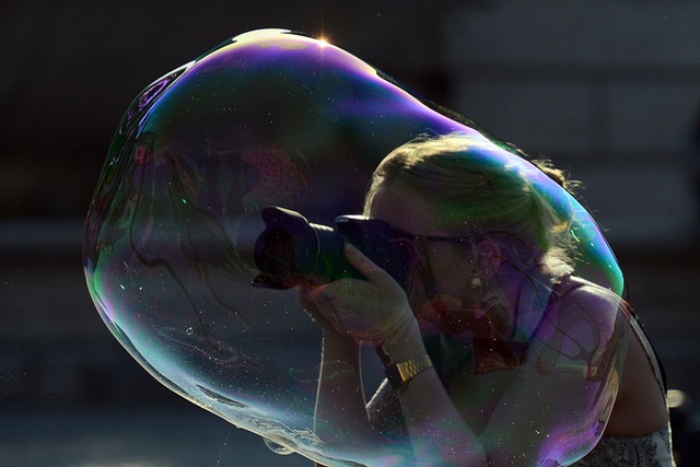 Nữ du khách chụp ảnh bong bóng do một người bán dạo thổi trên đường phố ở Rome, Italia.