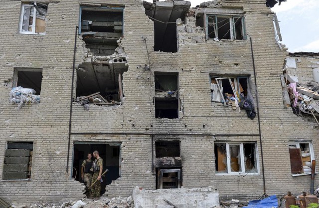 Thành viên của lực lượng vũ trang Ukraine đứng trong tòa nhà bị phá hủy trong cuộc giáo tranh với phe lý khai thân Nga tại ngôi làng Pesky ở vùng Donetsk.