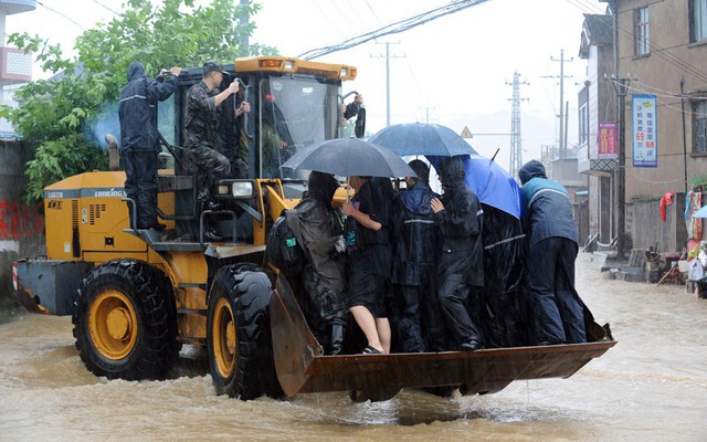 Xe ủi được sử dụng để sơ tán người dân khỏi khu vực ngập lụt do ảnh hưởng của bão Chan-hom tại tỉnh Chiết Giang Trung Quốc.