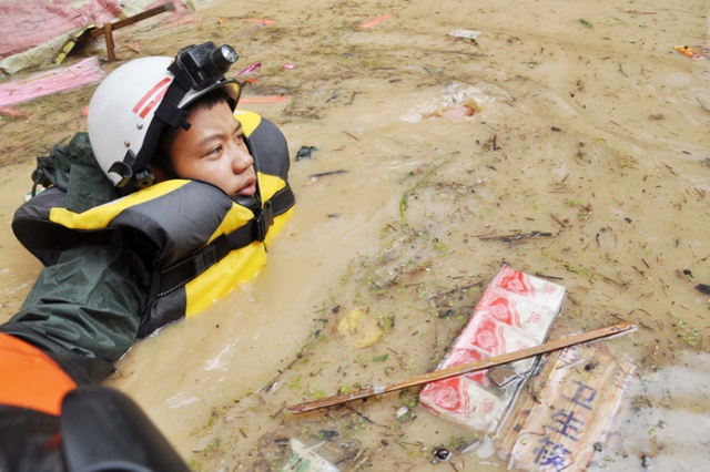 Nhân viên cứu hộ di chuyển trong nước lũ để tìm kiếm những nạn nhân bị mắc kẹt tại tỉnh Quý Châu, Trung Quốc.