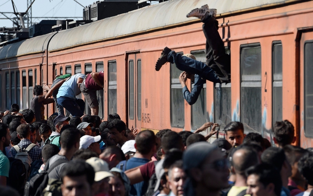 Những người nhập cư trèo qua cửa sổ đoàn tàu tới Serbia tại nhà ga ở Gevgelija, Macedonia.