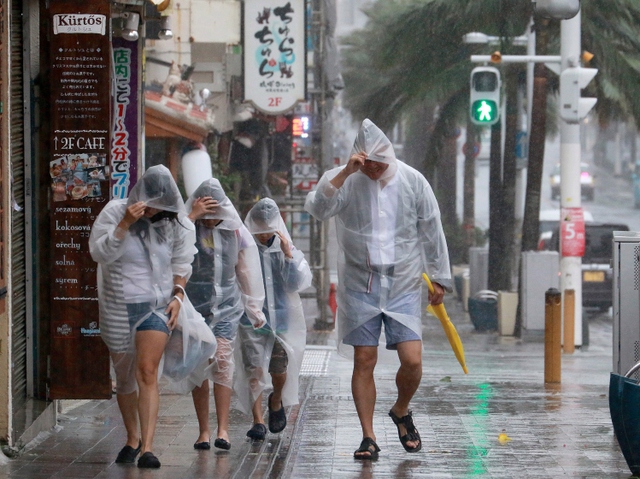Du khách đi dưới mưa khi siêu bão Goni đổ bộ vào Okinawa, Nhật Bản.