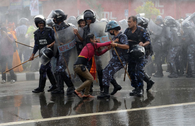 Cảnh sát chống bạo động bắt giữ một phụ nữ tham gia biểu tình trước tòa nhà quốc hội tại thủ đô Kathmandu, Nepal.