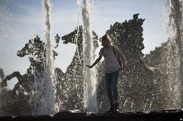 
Bé gái chơi trên đài phun nước gần Điện Kremlin ở thành phố Moscow, Nga.
