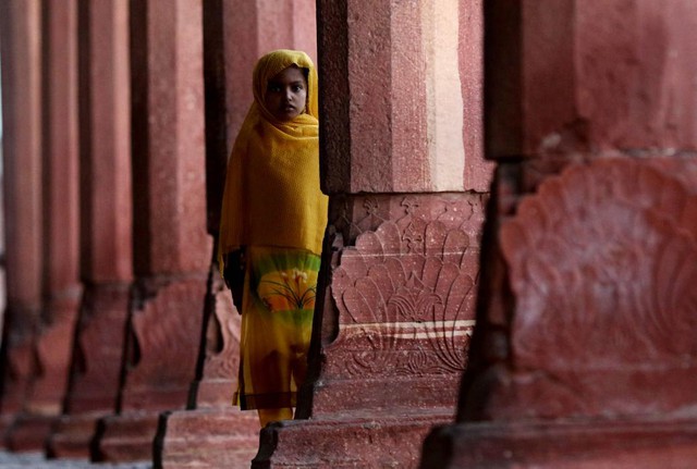 Bé gái đứng giữa hàng cột trong ngôi đền Diwan-e-Aam ở Lahore, Pakistan.