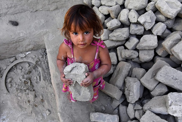 
Bé gái cầm một viên gạch từ ngôi nhà bị phá hủy trong trận động đất vào tuần trước ở Kunar, Afghanistan.
