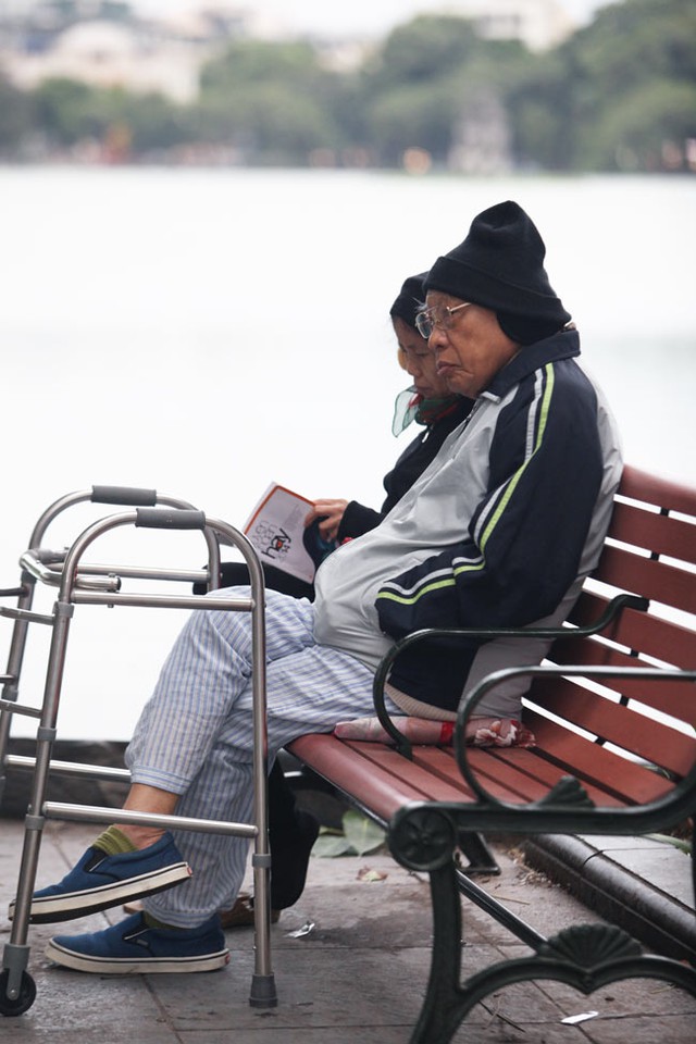 Hai cụ già ngồi đọc sách ven Hồ Gươm trong buổi chiều lạnh đầu tiên của mùa đông.