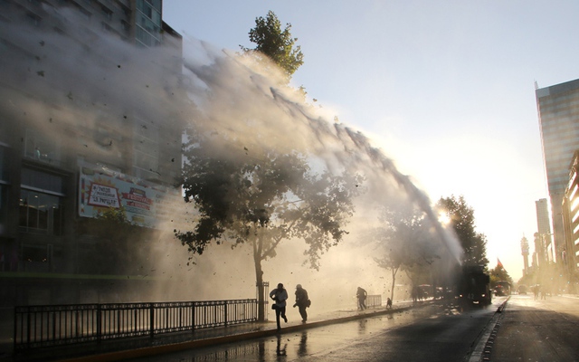 Cảnh sát chống bạo động dùng vòi rồng phun nước để giải tán sinh viên biểu tình ở thành phố Santiago, Chile.