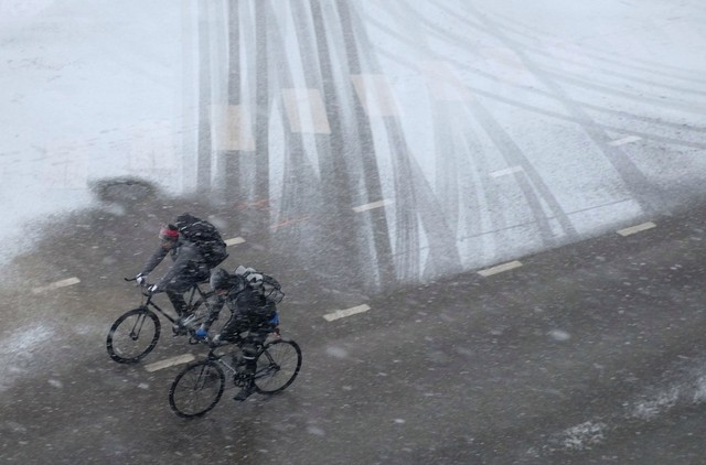 Mọi người đạp xe dưới mưa tuyết ở thành phố Chicago, Mỹ.