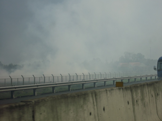 Những ruộng rơm đang bốc khói ngùn ngụt tràn vào đường cao tốc - Ảnh: Hữu Vinh