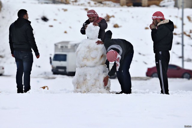 Mọi người thích thú chơi với tuyết ở Amman, Jordan.