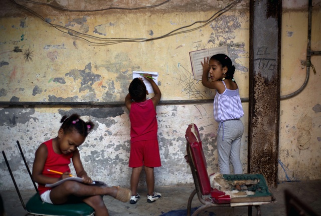 Trẻ em làm bài về nhà trong sân nhỏ của tòa nhà chung cư ở Havana, Cuba.