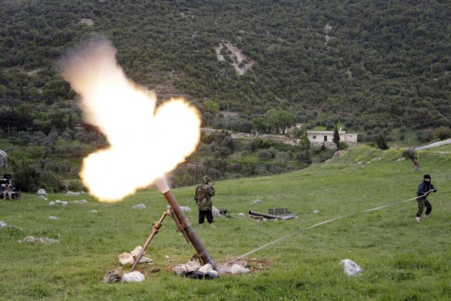 Chiến binh phiến quân Syria phóng đạn cối nhằm vào quân đội chính phủ tại vùng ngoại ô Hama.