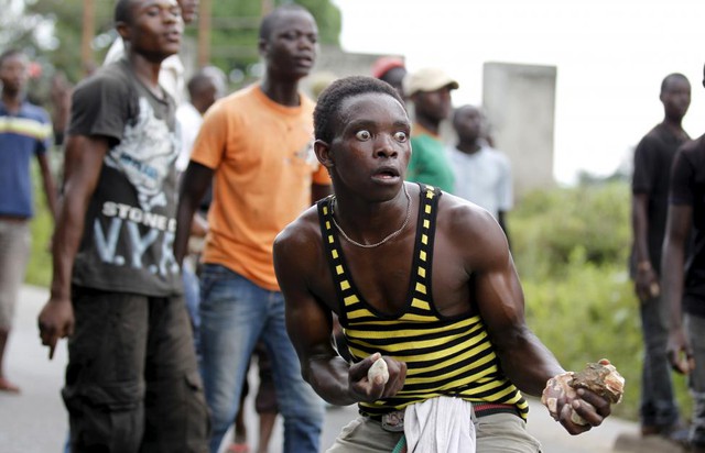 Người biểu tình chống chính phủ cầm đá trong cuộc đụng độ với cảnh sát tại thủ đô Bujumbura, Burundi.