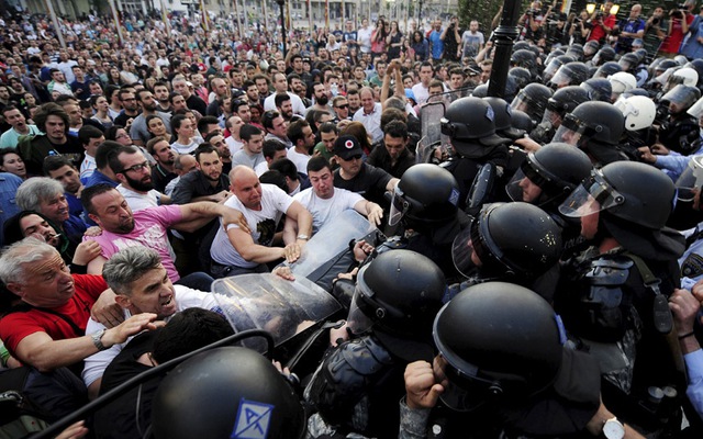 Người biểu tình đụng độ với cảnh sát chống bạo động bên ngoài tòa nhà chính phủ ở Skopje, Macedonia.