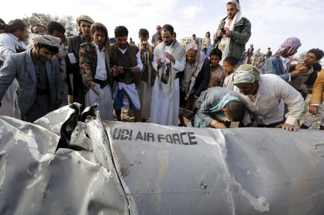 Mọi người kiểm tra một phần xác chiếc máy bay chiến đấu của Ả-rập Xê-út bị bắn rơi tại miền bắc thủ đô Sanaa, Yemen.