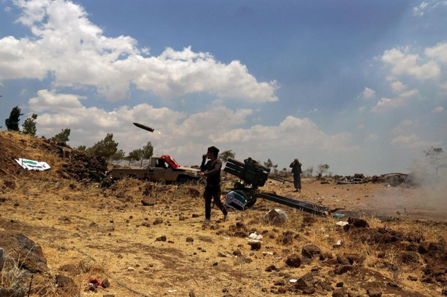 Các chiến binh phiến quân Syria phóng rocket nhằm vào quân đội chính phủ ở ngoại ô thành phố Quneitra.