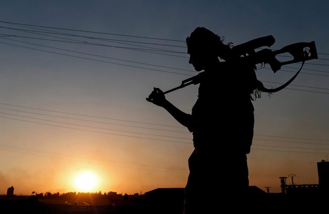Chiến binh người Kurd đứng bảo vệ gần thành phố Tel Abyad, Syria.
