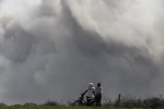 Cặp đôi nhìn tro bụi phun trào từ núi lửa Sinabung tại tỉnh North Sumatra, Indonesia.