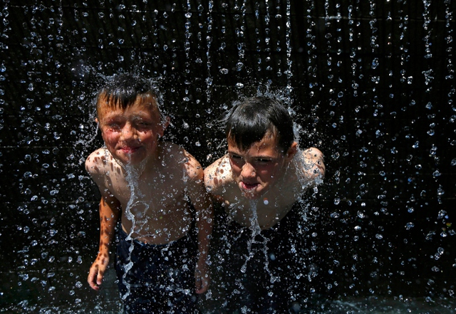 Trẻ em tắm mát trên đài phun nước ở Nottingham, Anh.