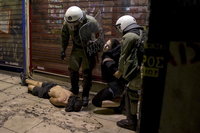 Cảnh sát chống bạo động bắt giữ một thanh niên bịt mặt trong cuộc xô xát tại Athens, Hi Lạp.