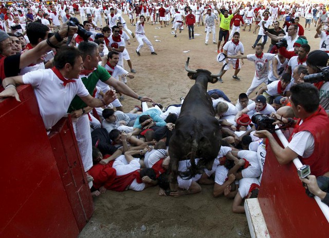 Bò trèo qua những người tham dự lễ hội bò rượt San Fermin ở thành phố Pamplona, Tây Ban Nha.