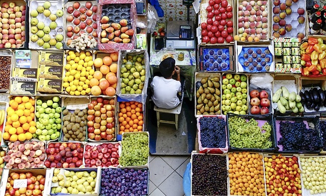 Cậu bé tranh thủ ăn trưa tại một quầy hàng bán trái cây trong khu chợ trung tâm ở thành phố Kazan, Nga.
