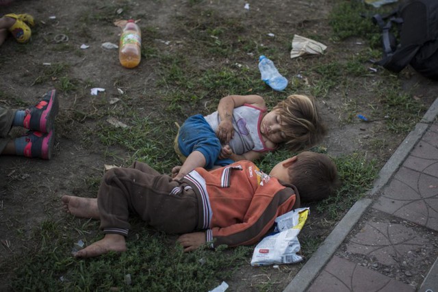 Trẻ em di cư Syria ngủ trên bãi cỏ trong công viên ở thành phố Belgrade, Serbia.