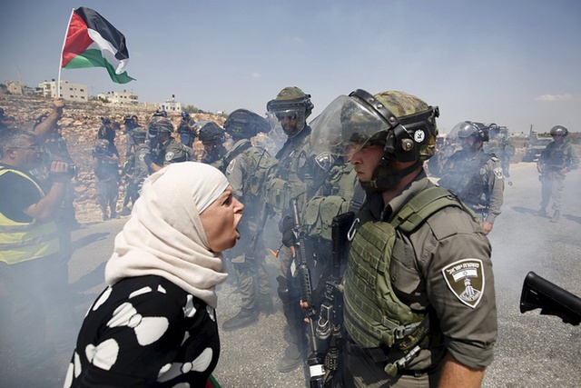 Người phụ nữ Palestine to tiếng với cảnh sát biên giới giới Israel trong cuộc biểu tình phản đối khu định cư của người Do Thái ở Ramallah, Bờ Tây.