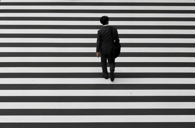
Người đàn ông đi qua đường tại khu phố thương mại ở Tokyo, Nhật Bản.
